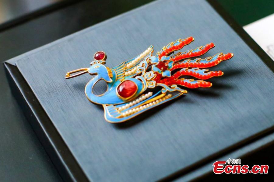 Artist Ma Jingji shows 30 pieces of Diancui works he has collected or created at an exhibition in Chongqing, Oct. 22, 2018. Diancui, or dotting with kingfishers, is a painstakingly time-consuming and precise practice of inlaying iridescent kingfisher feathers into accessories for the rich and noble. Craftsmen apply the shimmering feathers to jewelry, hairpins, bracelets, brooches, fans, and landscape panels. Instead of kingfisher feathers, goose feathers and ribbons are used nowadays to make art creations with diancui skills.(Photo: China News Service/Zhong Xin)