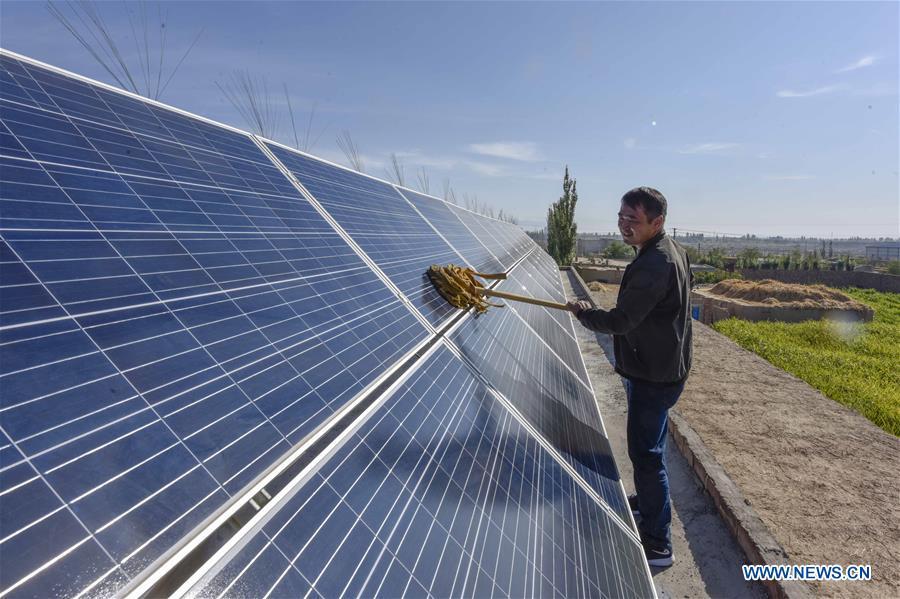 Villager Pan Linqi cleans solar panels in Hami, northwest China\'s Xinjiang Uygur Autonomous Region, Sept. 21, 2018. Xinjiang has seen a surge in the electricity generation from clean energy. According to State Grid Xinjiang Electric Power Co., Ltd., wind and solar power generated 27.81 billion and 9.07 billion kilowatt hours (kwh) of electricity, respectively, in the first nine months of 2018 in the region. With abundant wind and solar resources, Xinjiang is a pioneer in using new energy in China, with installed new-energy capacity having exceeded 27 million kilowatts so far. (Xinhua/Zhao Ge)