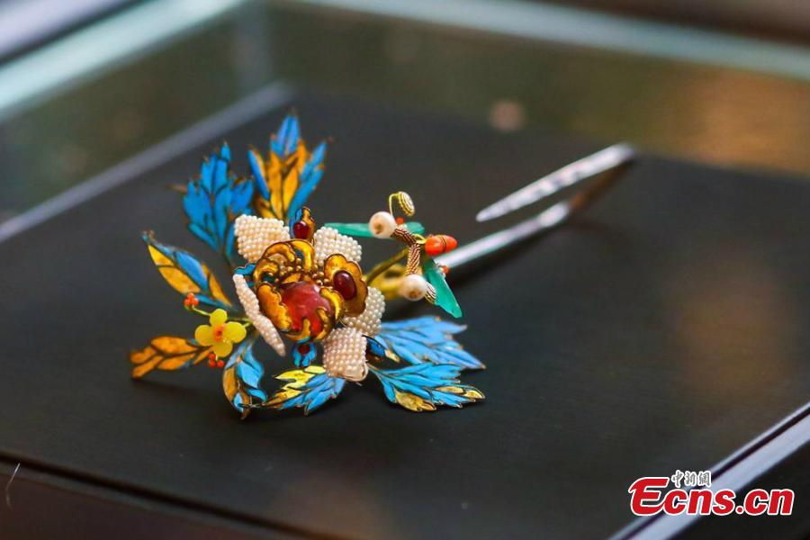 Artist Ma Jingji shows 30 pieces of Diancui works he has collected or created at an exhibition in Chongqing, Oct. 22, 2018. Diancui, or dotting with kingfishers, is a painstakingly time-consuming and precise practice of inlaying iridescent kingfisher feathers into accessories for the rich and noble. Craftsmen apply the shimmering feathers to jewelry, hairpins, bracelets, brooches, fans, and landscape panels. Instead of kingfisher feathers, goose feathers and ribbons are used nowadays to make art creations with diancui skills.(Photo: China News Service/Zhong Xin)