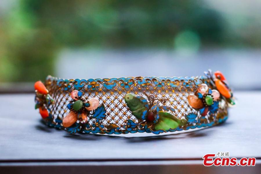 Artist Ma Jingji shows 30 pieces of Diancui works he has collected or created at an exhibition in Chongqing, Oct. 22, 2018. Diancui, or dotting with kingfishers, is a painstakingly time-consuming and precise practice of inlaying iridescent kingfisher feathers into accessories for the rich and noble. Craftsmen apply the shimmering feathers to jewelry, hairpins, bracelets, brooches, fans, and landscape panels. Instead of kingfisher feathers, goose feathers and ribbons are used nowadays to make art creations with diancui skills.(Photo: China News Service/Zhong Xin)