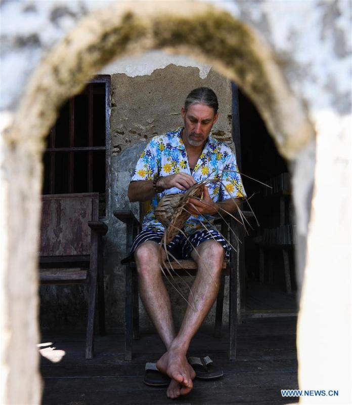 Canadian Craig Anderson makes artwork on the West Island in Sanya, south China\'s Hainan Province, Sept. 20, 2018. Anderson arrived in February at the West Island inhabited by around 4,000 people. Locals regarded Anderson as a scavenger when he first arrived, as he wandered around the beach almost every day, picking up driftwood, plastic bottles, shattered glasses, and rusty pieces of iron. As time went by, the locals realized that Anderson is an artist who devotes himself in environment protection art design. He profits the recyclable and regenerative materials in making art works. (Xinhua/Yang Guanyu)