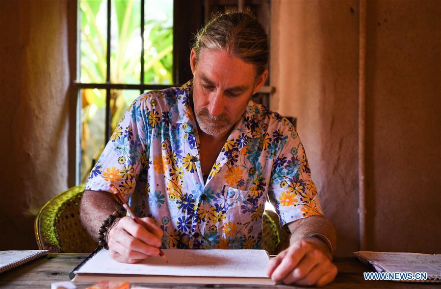 Canadian Craig Anderson works on the West Island in Sanya, south China\'s Hainan Province, Sept. 20, 2018. Anderson arrived in February at the West Island inhabited by around 4,000 people. Locals regarded Anderson as a scavenger when he first arrived, as he wandered around the beach almost every day, picking up driftwood, plastic bottles, shattered glasses, and rusty pieces of iron. As time went by, the locals realized that Anderson is an artist who devotes himself in environment protection art design. He profits the recyclable and regenerative materials in making art works. (Xinhua/Yang Guanyu)