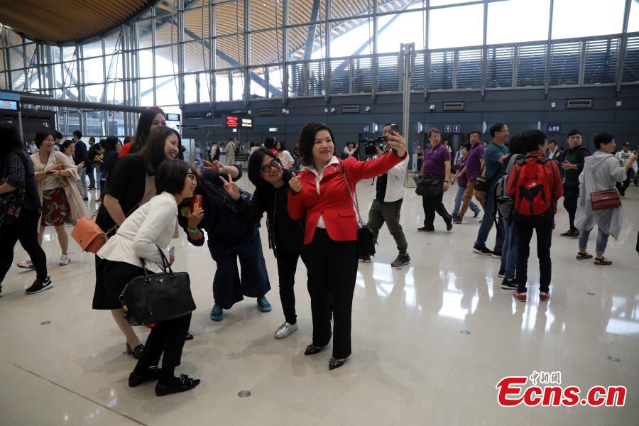 Passengers pose in Hong Kong before boarding coaches that will pass over the Hong Kong-Zhuhai-Macao Bridge Oct. 24, 2018. (Photo: China News Service/Sheung Man Mak)