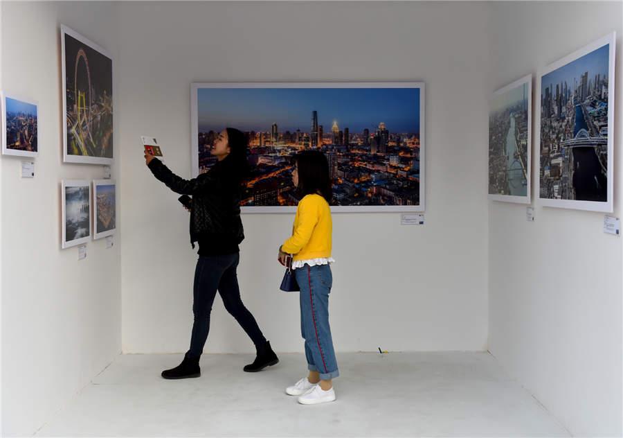 Visitors look at aerial photography works displayed at Photo Beijing 2018 in Beijing, Oct. 20, 2018. (Photo/Xinhua)