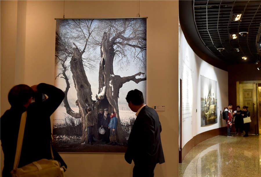 Visitors look at a documentary photography work displayed at Photo Beijing 2018 in Beijing, Oct. 20, 2018. (Photo/Xinhua)
