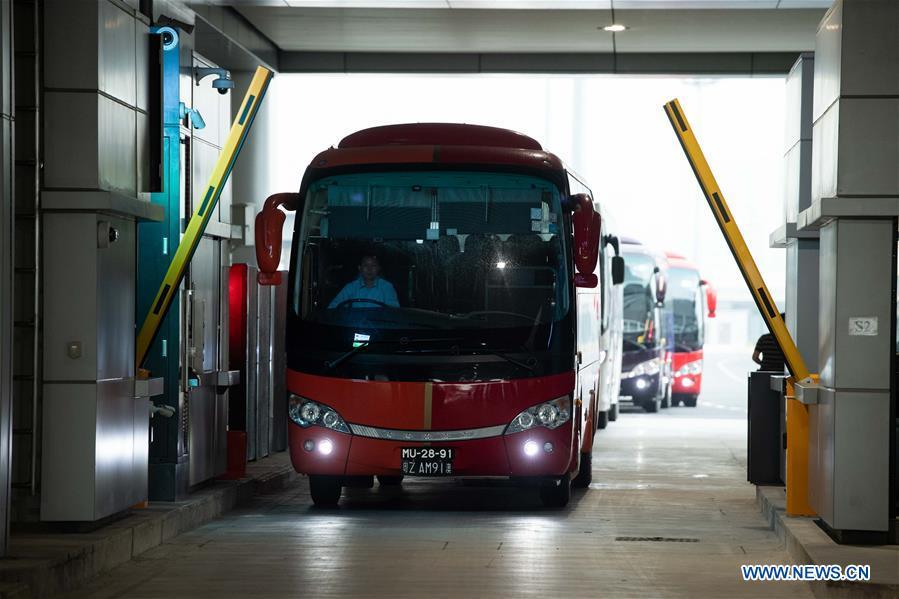A shuttle bus goes through the Macao port of the Hong Kong-Zhuhai-Macao Bridge, Oct. 24, 2018. The Hong Kong-Zhuhai-Macao bridge, the world\'s longest cross-sea bridge, opened to public traffic at 9 a.m. Wednesday. (Xinhua/Cheong Kam Ka)