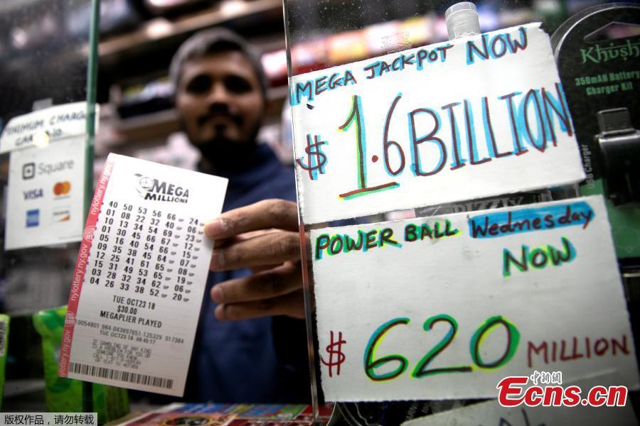 A newsstand vendor takes a customer\'s cash for tickets in Tuesday\'s Mega Millions and Wednesday\'s Powerball lottery drawings in New York City, New York, U.S., Oct. 23, 2018. One winning ticket was sold for the record Mega Millions jackpot of what turned out to be just under $1.6 billion. The winning ticket was purchased in South Carolina at the KC Mart #7 in Simpsonville, in the northwest part of the state. The lucky winner has not yet been identified. (Photo/Agencies)