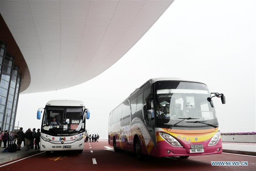 Shuttle buses arrive at the Zhuhai port of the Hong Kong-Zhuhai-Macao Bridge, in Zhuhai, south China\'s Guangdong Province, Oct. 24, 2018. The Hong Kong-Zhuhai-Macao bridge, the world\'s longest cross-sea bridge, opened to public traffic at 9 a.m. Wednesday. (Xinhua/Wang Shen)