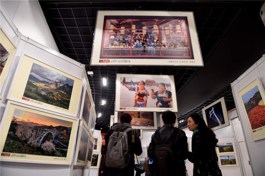 Visitors look at mobile photography works displayed at Photo Beijing 2018 in Beijing, Oct. 20, 2018. (Photo/Xinhua)