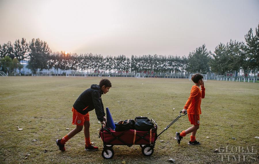 Two young players return the training equipment to the warehouse after training at the Shandong Luneng Taishan Football School in Weifang, East China\'s Shandong Province, on October 24, 2018. (Photo: Li Hao/GT)