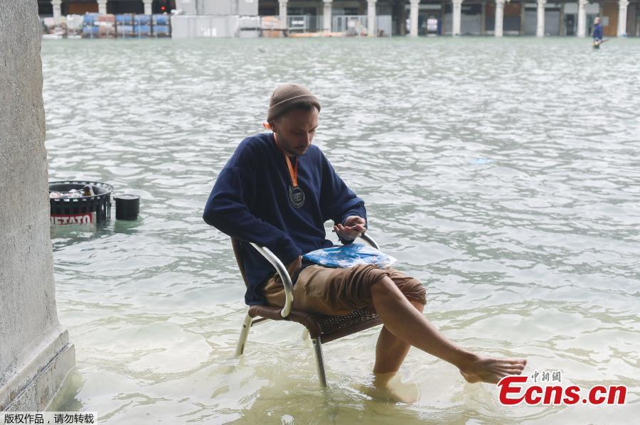 A man sits on a chair in the flooded St. Mark Square during a high-water alert in Venice on October 29, 2018. The flooding, caused by a convergence of high tides and a strong Sirocco wind, reached around 150 centimetres on October 29, 2018. (Photo/Agencies)