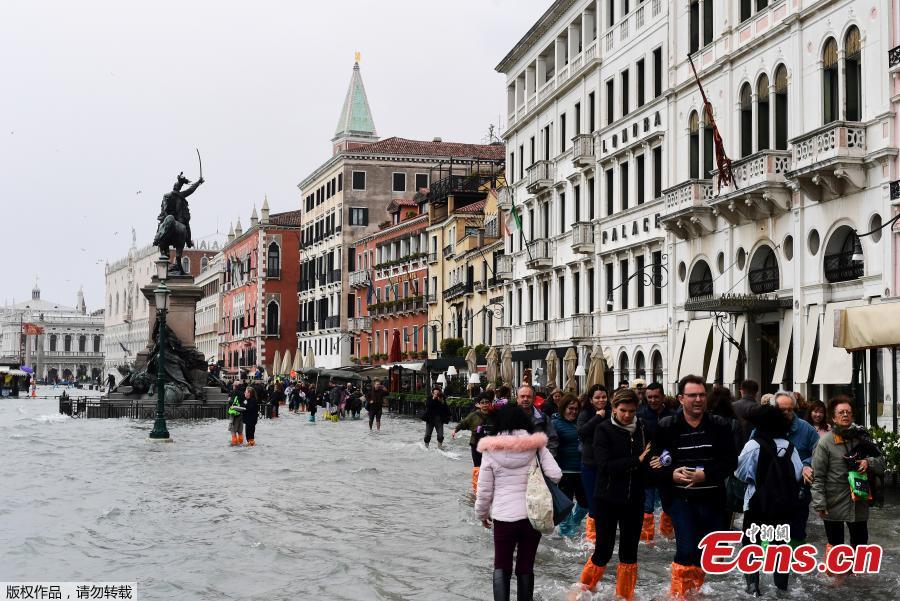 People walk in the flooded Riva degli Schiavoni during a high-water alert in Venice on October 29, 2018. The flooding, caused by a convergence of high tides and a strong Sirocco wind, reached around 150 centimetres on October 29, 2018. (Photo/Agencies)