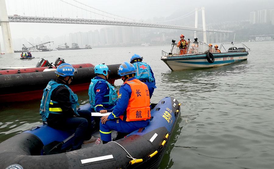 Rescuers search on Monday for passengers who were aboard a bus that plunged into the Yangtze River in Chongqing. (Photo by Zhao Hui/For China Daily)
Vehicle located 71 meters beneath water\'s surface; 2 bodies recovered
Rescuers have drafted a plan to salvage a bus that broke through a guardrail and plunged into the Yangtze River with an estimated 15 passengers onboard in Chongqing municipality on Sunday morning.
Two bodies were recovered from the water.
With the help of sonar, rescuers located the bus 71 meters below the surface, the Ministry of Emergency Management said in a statement on Monday.
Divers will attach ropes from floating cranes to lift the vehicle out, the statement said.