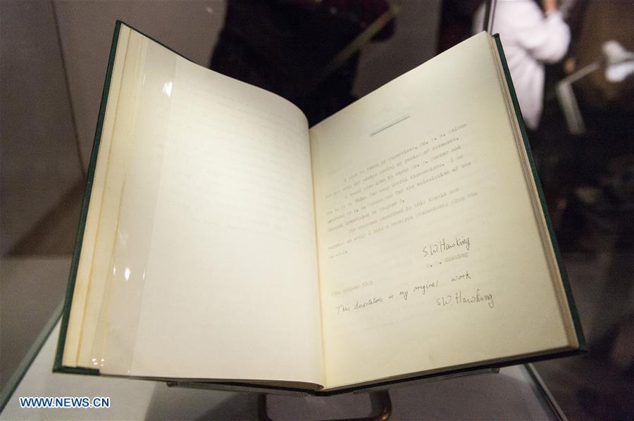 A copy of Stephen Hawking\'s Cambridge University Ph.D. thesis is seen during a photocall for an online auction in London, Britain, on Oct. 30, 2018. An online sale of 22 items from the late physicist Stephen Hawking by auctioneer Christie\'s will open for bids on Oct. 31. The auction will include some of Hawking\'s complex scientific papers, one of his iconic wheelchairs and a script from the famous TV comedy show \