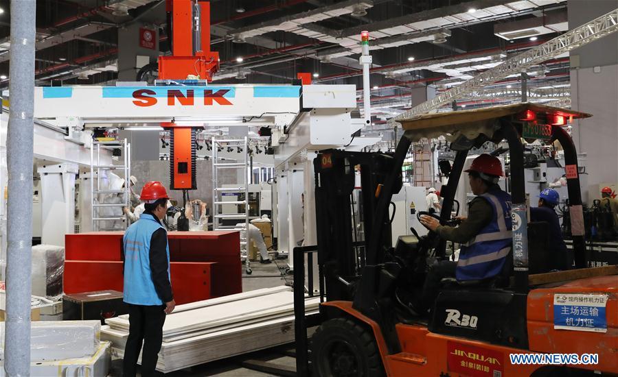 Workers carry materials at an exhibition hall in the National Exhibition and Convention Center (Shanghai) in Shanghai, east China, on Oct. 30, 2018. The final work is underway to get all eight exhibition halls ready for the first China International Import Expo (CIIE), scheduled to be held from Nov. 5 to 10. (Xinhua/Fang Zhe)