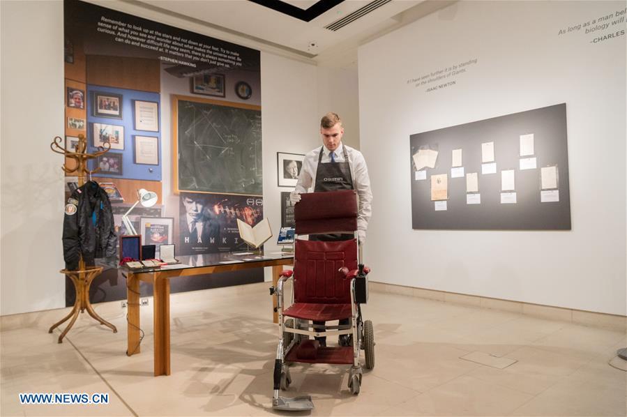 A staff member of auctioneer Christie\'s shows Stephen Hawking\'s wheelchair during a photocall for an online auction in London, Britain, on Oct. 30, 2018. An online sale of 22 items from the late physicist Stephen Hawking by auctioneer Christie\'s will open for bids on Oct. 31. The auction will include some of Hawking\'s complex scientific papers, one of his iconic wheelchairs and a script from the famous TV comedy show \