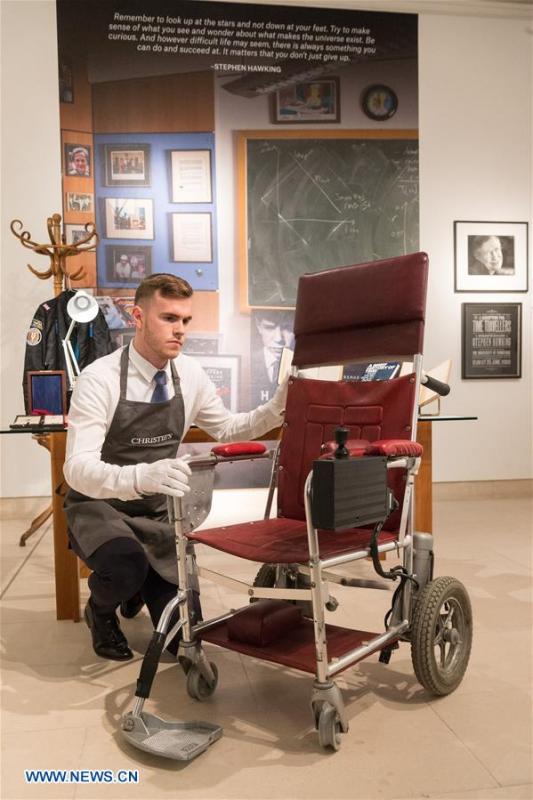 A staff member of auctioneer Christie\'s shows Stephen Hawking\'s wheelchair during a photocall for an online auction in London, Britain, on Oct. 30, 2018. An online sale of 22 items from the late physicist Stephen Hawking by auctioneer Christie\'s will open for bids on Oct. 31. The auction will include some of Hawking\'s complex scientific papers, one of his iconic wheelchairs and a script from the famous TV comedy show \