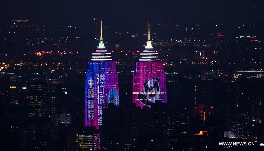 Photo taken on Nov. 2, 2018 shows the images of the logo and mascot of the China International Import Expo (CIIE) cast on buildings in Shanghai, east China. The first CIIE will be held on Nov. 5-10 in Shanghai. (Xinhua/Wang Jianhua)