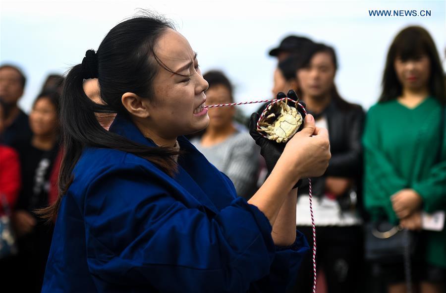 A woman takes part in a crab binding contest in Sihong County, east China\'s Jiangsu Province, Nov. 3, 2018. A total of 100 contestants participated in the event on Saturday. The winner bound 30 crabs within 3 minutes and 59 seconds. (Xinhua/Li Xiang)