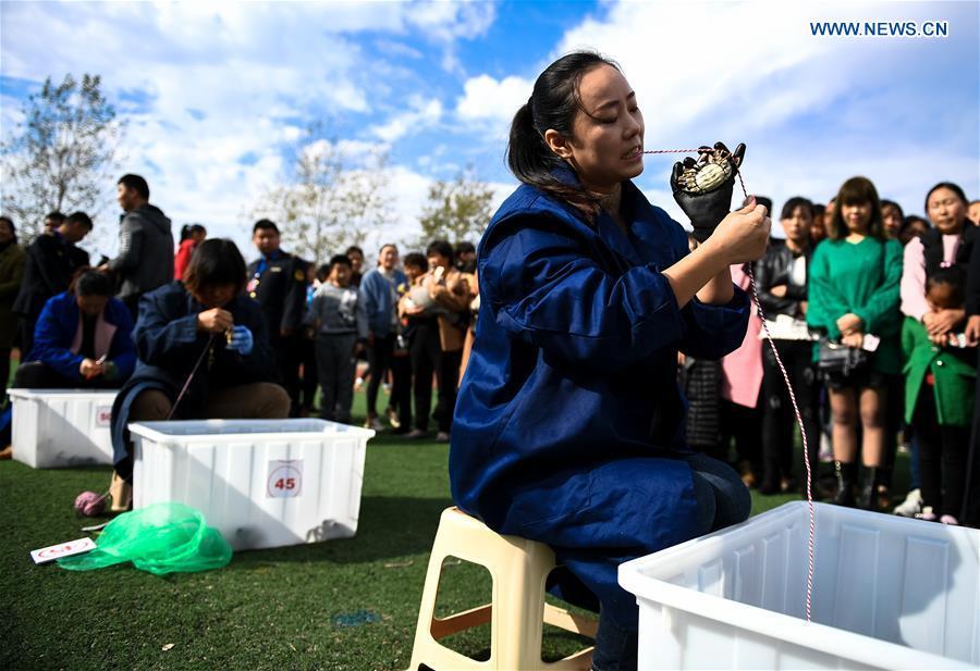 A woman takes part in a crab binding contest in Sihong County, east China\'s Jiangsu Province, Nov. 3, 2018. A total of 100 contestants participated in the event on Saturday. The winner bound 30 crabs within 3 minutes and 59 seconds. (Xinhua/Li Xiang)
