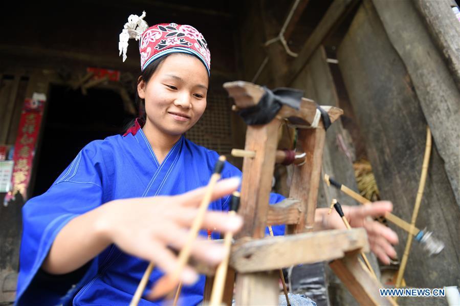 Yang Xinghe weaves ribbon at Xinjiang Village in Taijiang County of Qiandongnan Miao and Dong Autonomous Prefecture, southwest China\'s Guizhou Province, on Nov. 4, 2018. Born with hearing loss, Yang Xinghe, 28, is a female of the Miao ethnic group, who are engaged in Miao embroidery at the village. She learned embroidery from her mother when she was only a child, and has been a locally well-known master now. (Xinhua/Liu Kaifu)