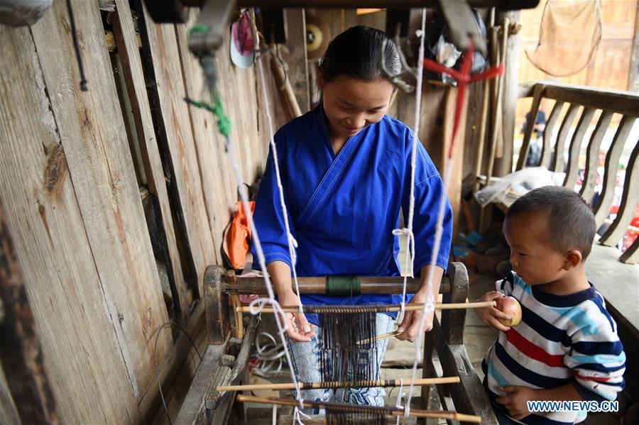 Yang Xinghe (L) weaves at Xinjiang Village in Taijiang County of Qiandongnan Miao and Dong Autonomous Prefecture, southwest China\'s Guizhou Province, on Nov. 4, 2018. Born with hearing loss, Yang Xinghe, 28, is a female of the Miao ethnic group, who are engaged in Miao embroidery at the village. She learned embroidery from her mother when she was only a child, and has been a locally well-known master now. (Xinhua/Liu Kaifu)