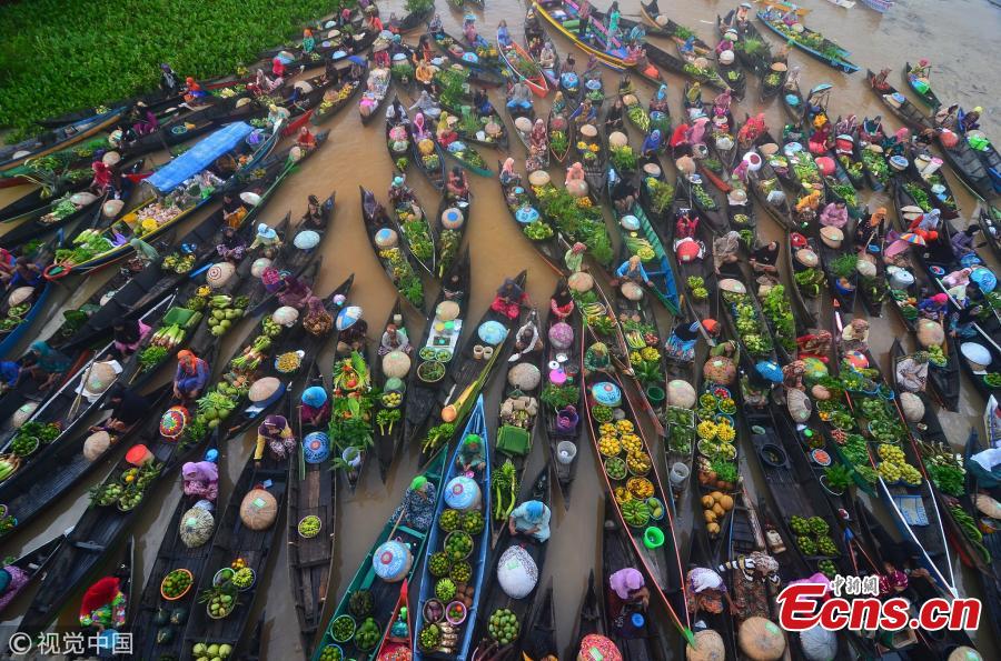 Hundreds of colorful boats tightly cram together at the Lok Baintan Floating Market to sell their hand-picked exotic fruit and vegetable in the Banjar district of Indonesia. The Lok Baintan floating market is in Southern Kalimantan Island dates back more than 500 years. Local people rely heavily on the waterways to make a living, with the markets now becoming tourist attractions. (Photo/VCG)