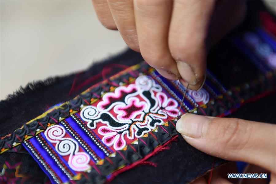 Yang Xinghe shows embroidery skills at Xinjiang Village in Taijiang County of Qiandongnan Miao and Dong Autonomous Prefecture, southwest China\'s Guizhou Province, on Nov. 4, 2018. Born with hearing loss, Yang Xinghe, 28, is a female of the Miao ethnic group, who are engaged in Miao embroidery at the village. She learned embroidery from her mother when she was only a child, and has been a locally well-known master now. (Xinhua/Liu Kaifu)