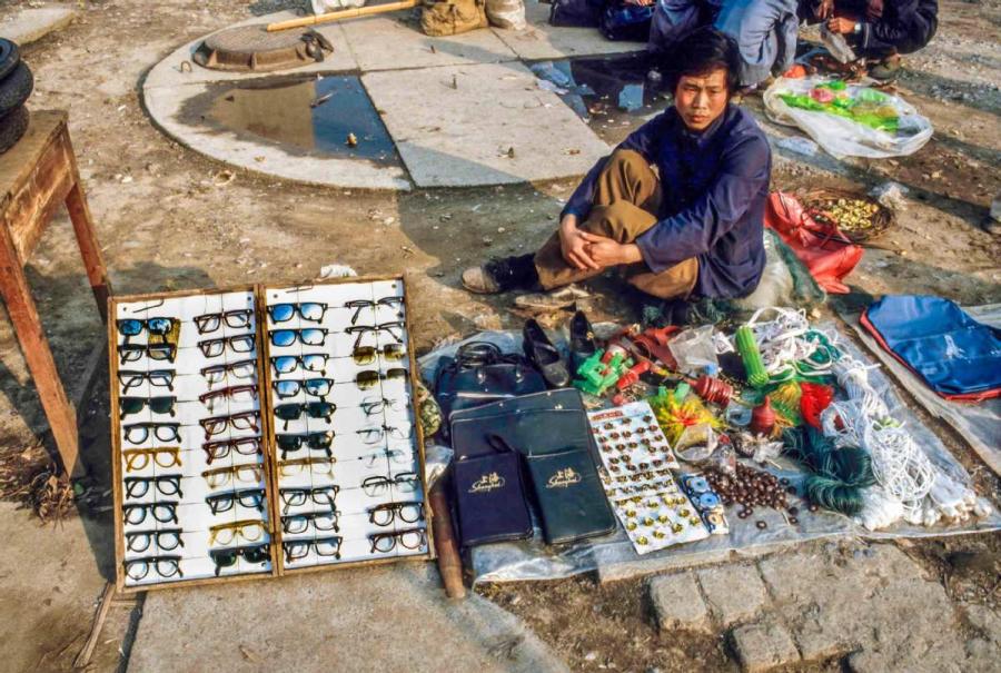 A man selling toys and sunglasses on the street in Guilin, South China\'s Guangxi Zhuang autonomous region. (Photo by Jamie Fouss/provided to chinadaily.com.cn)