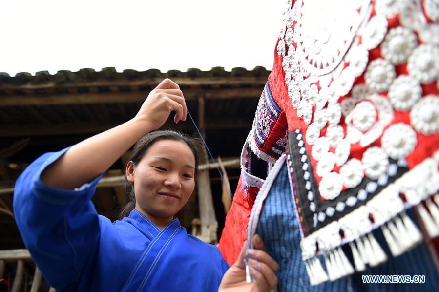 Yang Xinghe embroiders Miao clothes at Xinjiang Village in Taijiang County of Qiandongnan Miao and Dong Autonomous Prefecture, southwest China\'s Guizhou Province, on Nov. 4, 2018. Born with hearing loss, Yang Xinghe, 28, is a female of the Miao ethnic group, who are engaged in Miao embroidery at the village. She learned embroidery from her mother when she was only a child, and has been a locally well-known master now. (Xinhua/Liu Kaifu)