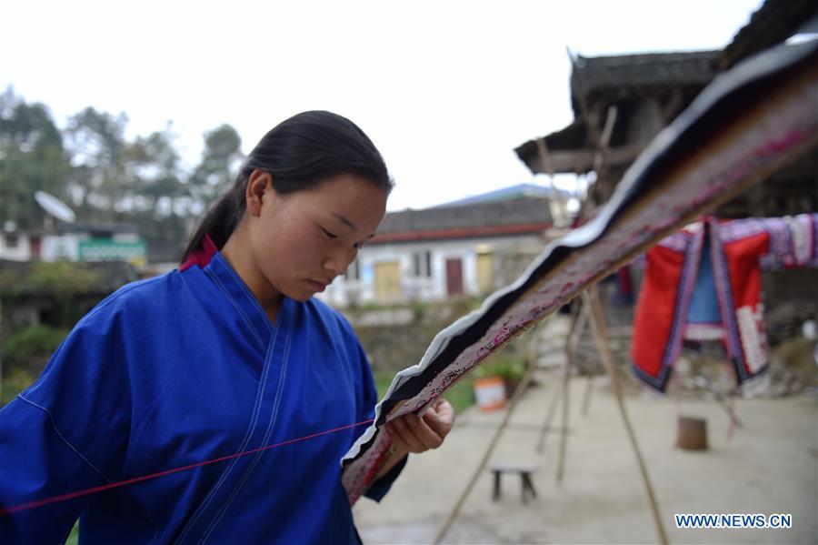 Yang Xinghe shows embroidery skills at Xinjiang Village in Taijiang County of Qiandongnan Miao and Dong Autonomous Prefecture, southwest China\'s Guizhou Province, on Nov. 4, 2018. Born with hearing loss, Yang Xinghe, 28, is a female of the Miao ethnic group, who are engaged in Miao embroidery at the village. She learned embroidery from her mother when she was only a child, and has been a locally well-known master now. (Xinhua/Liu Kaifu)