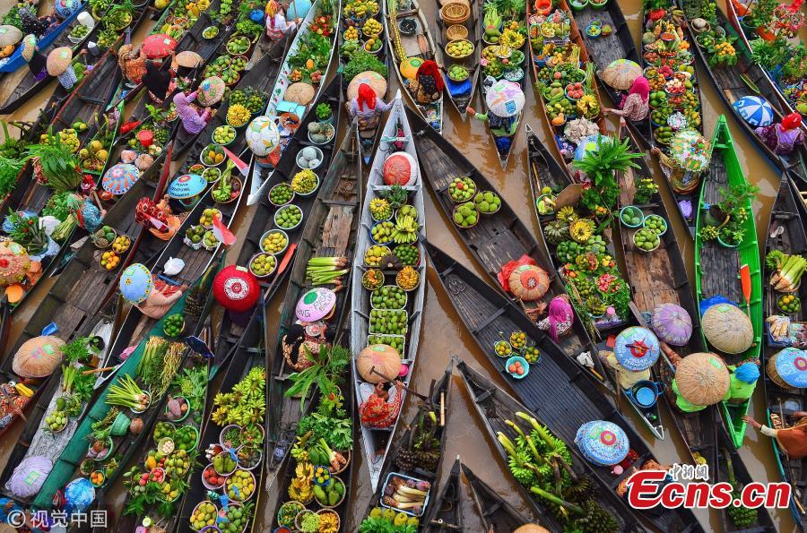Hundreds of colorful boats tightly cram together at the Lok Baintan Floating Market to sell their hand-picked exotic fruit and vegetable in the Banjar district of Indonesia. The Lok Baintan floating market is in Southern Kalimantan Island dates back more than 500 years. Local people rely heavily on the waterways to make a living, with the markets now becoming tourist attractions. (Photo/VCG)