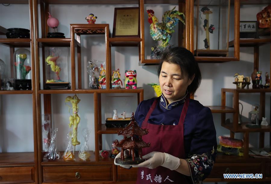 Folk artist Li Fengyan shows one of her sugar sculptures in Shenyang, northeast China\'s Liaoning Province, Nov. 6, 2018. The sugar sculpture of the Li family was listed as an intangible cultural heritage by the city of Shenyang. As the fifth-generation inheritor of her family\'s craft, Li Fengyan is making efforts to pass down the set of sugar-sculpting know-hows to her apprentices. (Xinhua/Yang Qing)