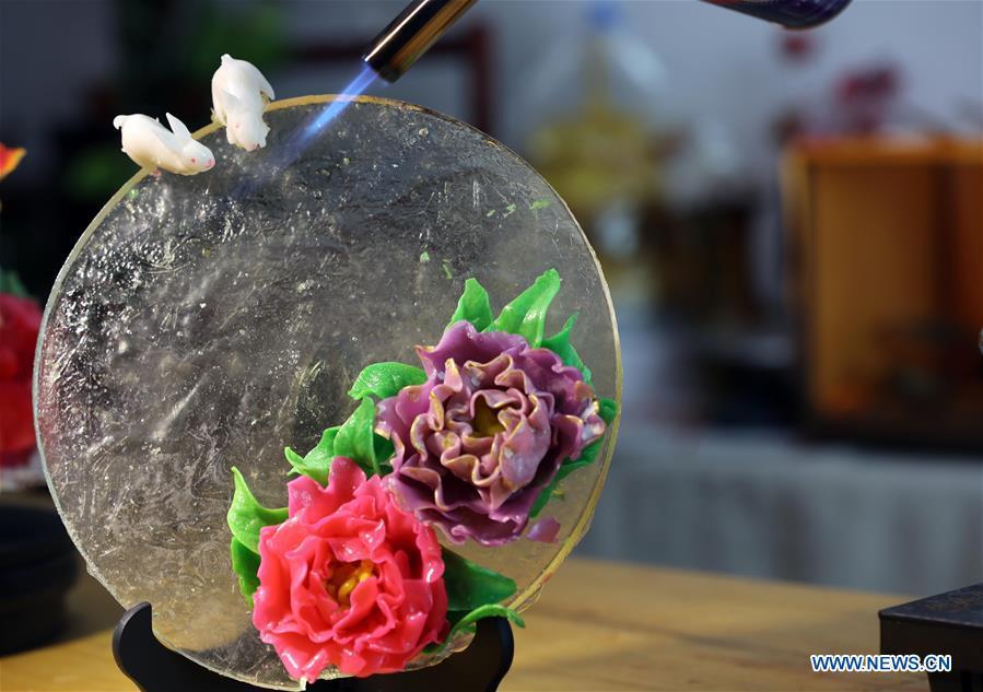 Folk artist Li Fengyan works on a sugar sculpture in Shenyang, northeast China\'s Liaoning Province, Nov. 6, 2018. The sugar sculpture of the Li family was listed as an intangible cultural heritage by the city of Shenyang. As the fifth-generation inheritor of her family\'s craft, Li Fengyan is making efforts to pass down the set of sugar-sculpting know-hows to her apprentices. (Xinhua/Yang Qing)
