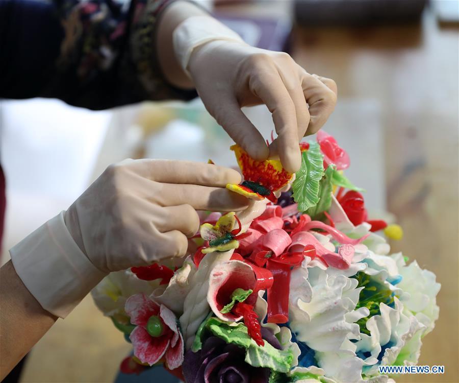 Folk artist Li Fengyan works on a sugar sculpture in Shenyang, northeast China\'s Liaoning Province, Nov. 6, 2018. The sugar sculpture of the Li family was listed as an intangible cultural heritage by the city of Shenyang. As the fifth-generation inheritor of her family\'s craft, Li Fengyan is making efforts to pass down the set of sugar-sculpting know-hows to her apprentices. (Xinhua/Yang Qing)