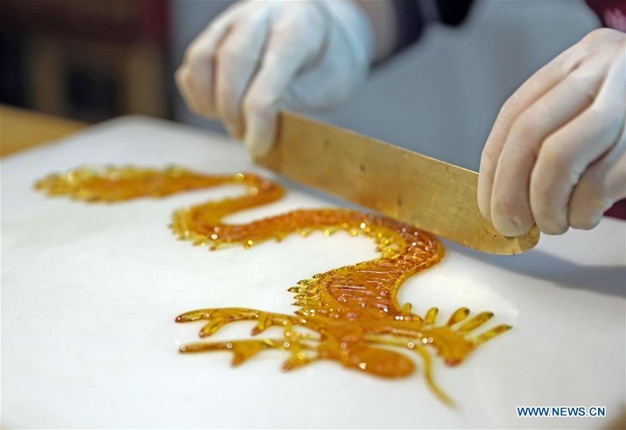 Folk artist Li Fengyan works on a sugar sculpture in Shenyang, northeast China\'s Liaoning Province, Nov. 6, 2018. The sugar sculpture of the Li family was listed as an intangible cultural heritage by the city of Shenyang. As the fifth-generation inheritor of her family\'s craft, Li Fengyan is making efforts to pass down the set of sugar-sculpting know-hows to her apprentices. (Xinhua/Yang Qing)