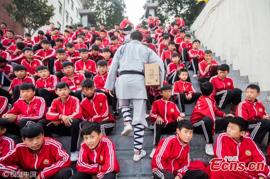 Wearing monk\'s robes, two Kung fu masters do a part time job as delivery man in Dengfeng city, Central China’s Henan province. With their special stunts of martial arts, the two can give a hand to local couriers in preparation for the approaching annual Singles Day online shopping extravaganza on November 11. (Photo/VCG)