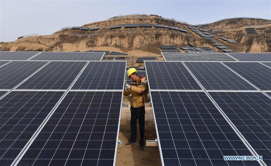 A worker checks solar panels at a photovoltaic power station built under an inter-village poverty relief program in Huojiaping Village of Yihe Township, Suide County, northwest China\'s Shaanxi Province, Nov. 7, 2018. Located on the Loess Plateau, Suide County has abundant sunshine and idle lands which are ideal for the construction of photovoltaic power stations. Currently, local authorities are working with a provincial branch of electricity service provider State Grid on a 33-megawatt photovoltaic power station. (Xinhua/Liu Xiao)