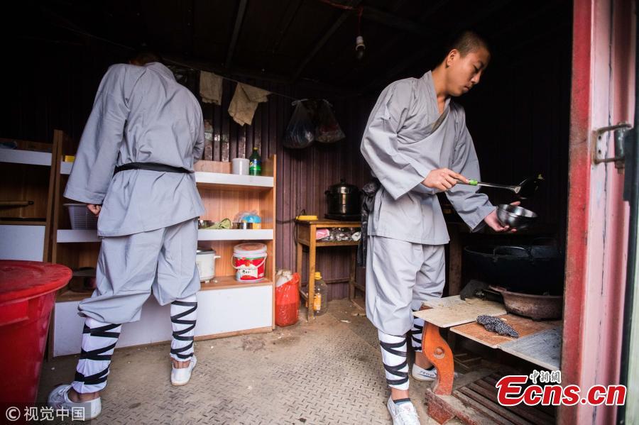 Wearing monk\'s robes, two Kung fu masters do a part time job as delivery man in Dengfeng city, Central China’s Henan province. With their special stunts of martial arts, the two can give a hand to local couriers in preparation for the approaching annual Singles Day online shopping extravaganza on November 11. (Photo/VCG)