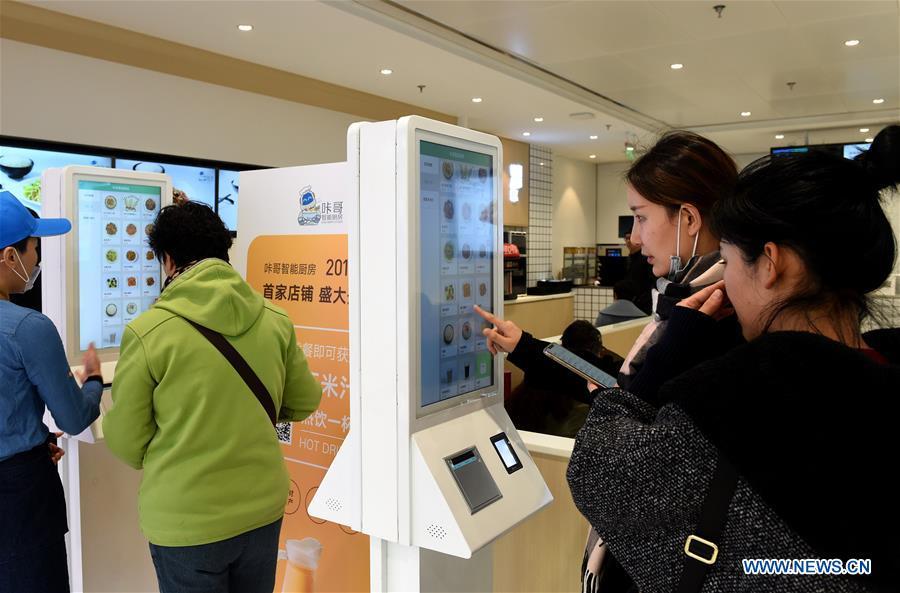 Customers order dishes in a cookless restaurant in central Beijing, capital of China, Nov. 7, 2018. The restaurant, equipped with 7 cooking machines that are programmed to prepare some popular Chinese dishes in minutes without human interference. Working along with smart payment and raw material supply systems, the cooking machine provides instant and standardized dishes. (Xinhua/Luo Xiaoguang)