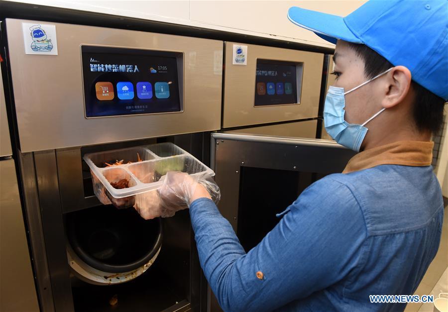 A worker operates a cooking machine in a cookless restaurant in central Beijing, capital of China, Nov. 7, 2018. The restaurant, equipped with 7 cooking machines that are programmed to prepare some popular Chinese dishes in minutes without human interference. Working along with smart payment and raw material supply systems, the cooking machine provides instant and standardized dishes. (Xinhua/Luo Xiaoguang)