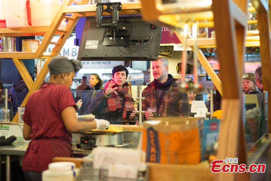 Customers wait for thier Jianbing, or the Chinese crepe at a kiosk in a food court in Brooklyn, New York, the United States on November 10, 2018. The Chinese snack ranges in cost from $13 to $15. (Photo: China News Service/ Liao Pan)