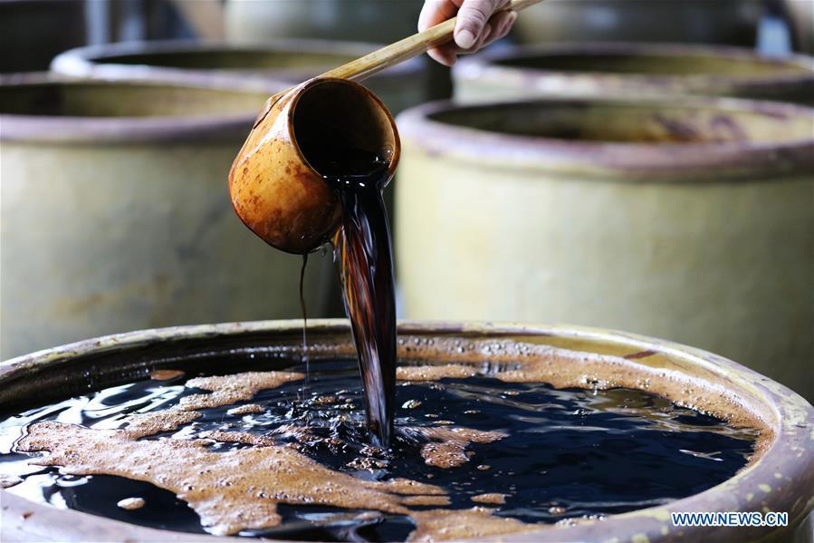 A worker shows the newly-made vinegar at a vinegar plant in Chishui, southwest China\'s Guizhou Province, Nov. 18, 2018. Chishui maintained a traditional method to make vinegar with over 30 process steps.(Xinhua/Wang Changyu)