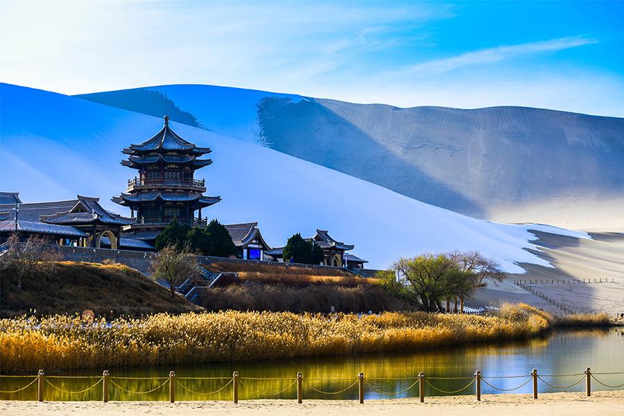 Dunhuang embraces this winter\'s first snowfall on Nov. 14. As the sun comes out, snow scenery in local landmark attractions like the Mingsha Mountain and Yueya Spring, a crescent-shaped spring-fed lake surrounded by desert, turns to a fairyland. (Photo/China Daily)
