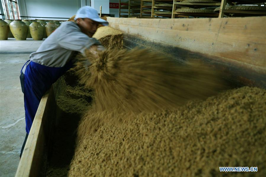 A worker stirs raw materials to make vinegar at a vinegar plant in Chishui, southwest China\'s Guizhou Province, Nov. 18, 2018. Chishui maintained a traditional method to make vinegar with over 30 process steps.(Xinhua/Wang Changyu)