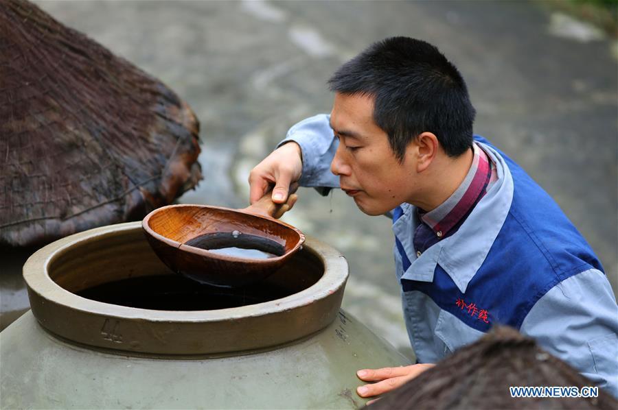 A worker checks vinegar aired in a jar at a vinegar plant in Chishui, southwest China\'s Guizhou Province, Nov. 18, 2018. Chishui maintained a traditional method to make vinegar with over 30 process steps.(Xinhua/Wang Changyu)