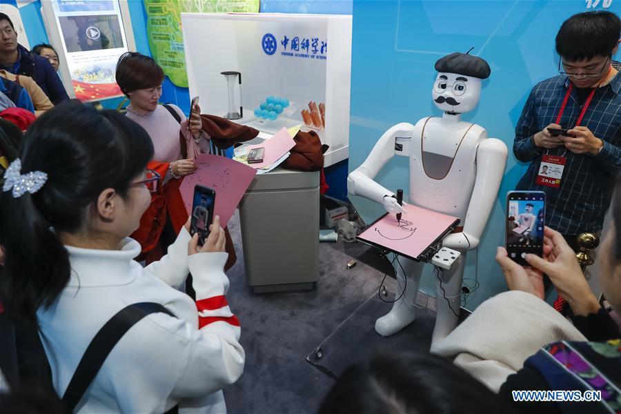 An intelligent painting robot with facial recognition function draws a portrait during a major exhibition to commemorate the 40th anniversary of China\'s reform and opening-up at the National Museum of China in Beijing, capital of China, Nov. 20, 2018. It can finish a portrait within three to five minutes. (Xinhua/Shen Bohan)