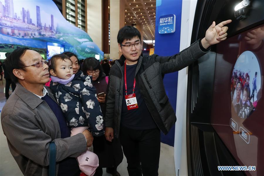 Visitors experience a musical interactive project of Xinhua News Agency during a major exhibition to commemorate the 40th anniversary of China\'s reform and opening-up at the National Museum of China in Beijing, capital of China, Nov. 20, 2018. The project generated pop music of different periods on the basis of gender and facial recognition. (Xinhua/Shen Bohan)