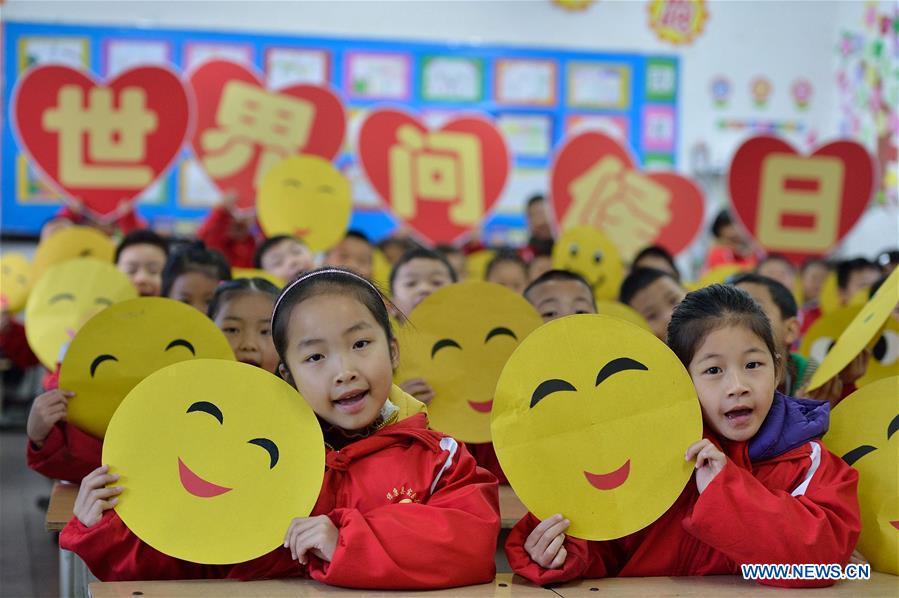 Children show greeting cards made to mark the World Hello Day which falls on Nov. 21 annually at the experimental primary school at Baokang County, central China\'s Hubei Province. (Xinhua/Yang Tao)
