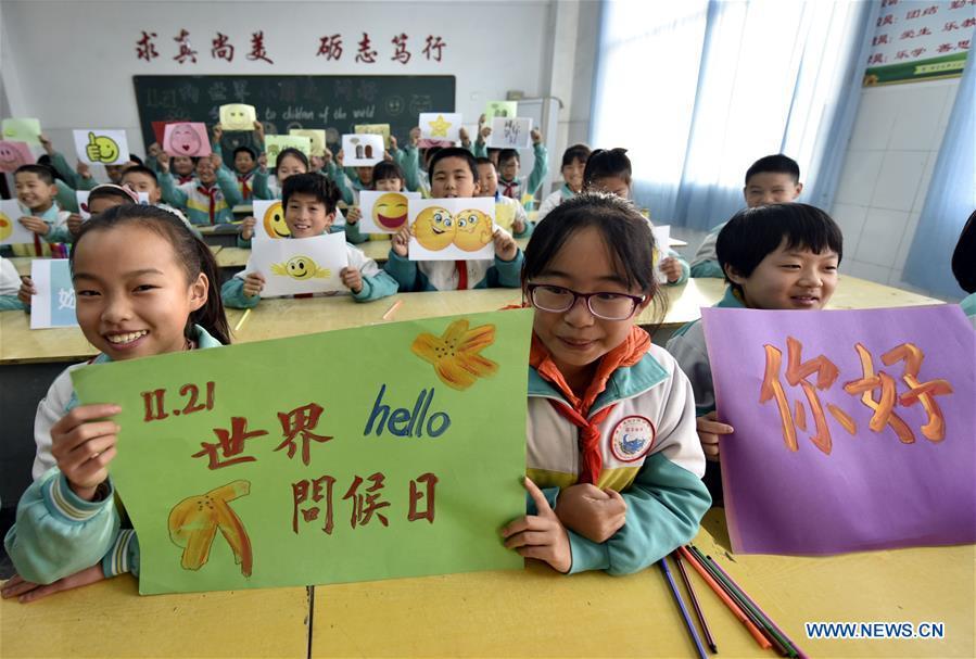Children show greeting cards made to mark the World Hello Day which falls on Nov. 21 annually at a center primary school at Yangguantun Township of Chiping County, east China\'s Shandong Province. (Xinhua/Zhao Yuguo)